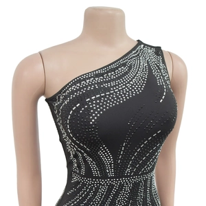 Detail of shimmering silver rhinestones in a wave pattern on black one-shoulder dress