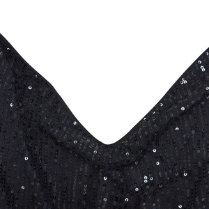 Détail du tissu à paillettes noires et décolleté en V profond sur une robe courte sexy