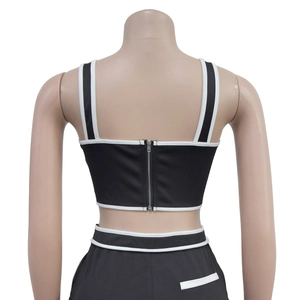 Detail view of the back silver zipper closure on a black and white cropped tank top
