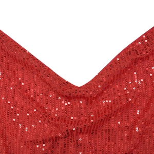 Détail macro de paillettes rouges sur tulle montrant la finition du col en V et la texture