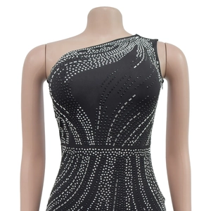 Detailed view of radiant silver rhinestones on a black one-shoulder evening dress