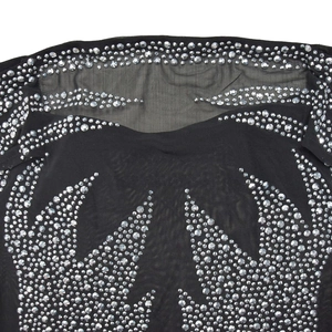 Détail du tissu en maille noire avec motifs symétriques d'ailes en strass argentés