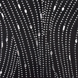 Détail macro du tissu en résille noire avec des motifs de vagues en strass de luxe