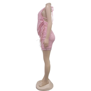 Détail d'une robe rose à paillettes avec dos nu et ourlet en plumes pour des soirées
