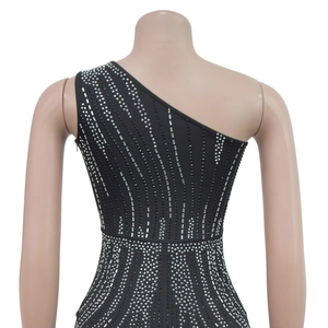 Detail of silver rhinestones on a black one-shoulder evening dress with a fitted waist