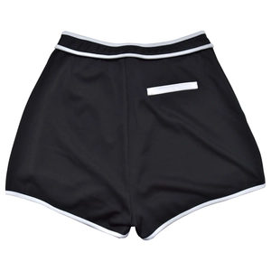 Detail of high-waisted black sports shorts with white contrast piping and back pocket