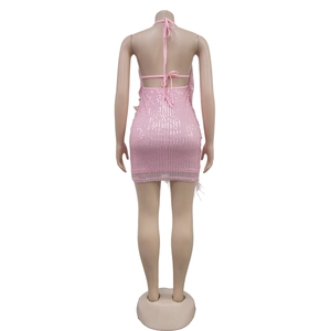 Détails du dos d'une robe moulante à paillettes roses avec licou et ourlet en plumes