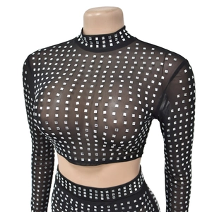 Detail of long sleeve black mesh top with silver rhinestones and high neck cut