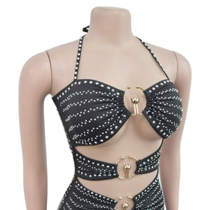 Detail of black rhinestone halter dress featuring hollow cutouts and gold metal rings