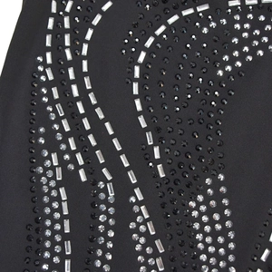 Macro detail of sparkling rhinestones and crystal patterns on a black fashion dress