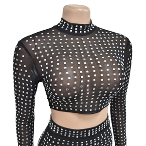 Detailed view of silver rhinestones on black mesh fabric for two-piece women's set