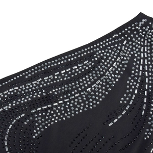 Detailed macro view of sparkling rhinestones in a wave pattern on black stretch fabric