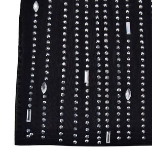 Vue macro d'une robe en tulle noir avec strass scintillants et détails de perles cristal