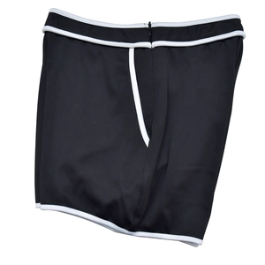 Close-up of black shorts with white contrast piping and hidden back zipper detail