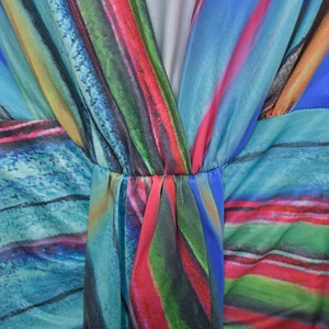 Détail du col en V avec plis et imprimé abstrait coloré sur le tissu de la robe