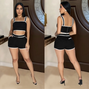 Women's two-piece black sports set with white trim, crop top and high waist shorts