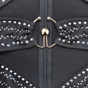 Detail of silver rhinestones and gold ring buckle on a black bodycon dress with zipper