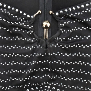 Detail of black dress featuring silver rhinestone waves and gold zipper hardware