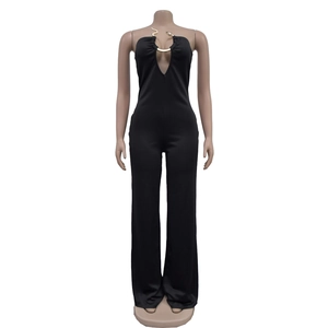 Detail of deep V-neck black jumpsuit featuring a decorative gold snake U-shaped metal ring