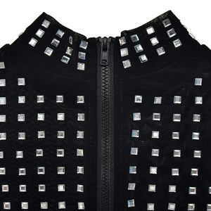 Close-up detail of silver rhinestones on black mesh fabric with a central zipper