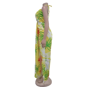 Detail view of yellow tropical leaf print maxi dress with halter neck and side high slit