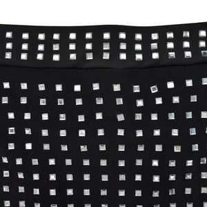 Detail shot of silver square rhinestones arranged in a grid pattern on black fabric