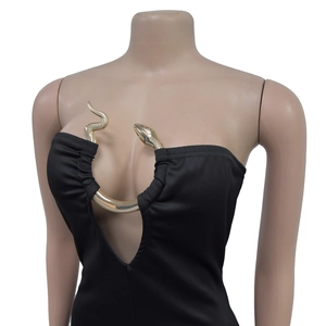 Detail of elegant black tube jumpsuit featuring a golden snake-shaped metal cutout decoration