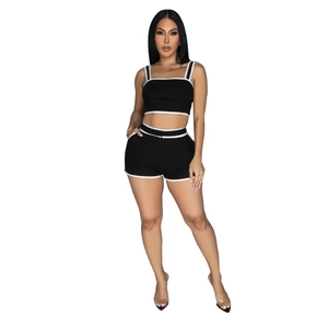 Detail of black sports two-piece set with white contrast piping and high-waist shorts