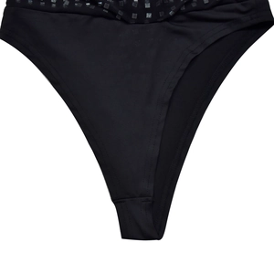 Detailed macro view of black high-cut bikini bottoms with silver sequins and mesh waist