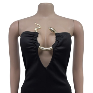 Detail of elegant black jumpsuit featuring a gold snake-shaped metal U-neckline ornament