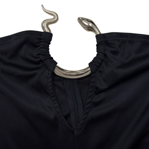 Detailed close-up of a silver snake hardware buckle on a black elegant jumpsuit neckline
