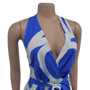Detail of blue and white printed sleeveless V-neck jumpsuit with waist tie and halter neck