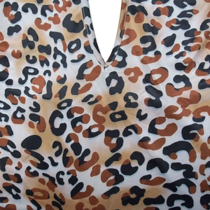 Détail du tissu à motif léopard avec col en V et texture synthétique lisse
