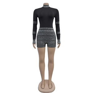 Close-up of sparkling silver rhinestones on a chic black long-sleeved mock neck bodysuit