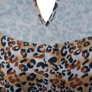 Détail du décolleté en V profond et du motif léopard avec des coutures blanches nettes