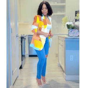 Close-up of a women's blazer featuring vibrant yellow, blue, and orange color-block pattern