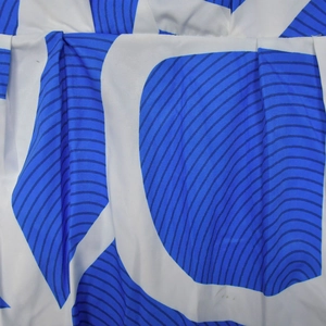 Detailed view of the modern blue abstract geometric wave pattern on white fabric