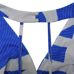 Close-up of blue and white geometric floral print with dual white buttons detail