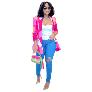 Detailed close-up of a women's color-block blazer with vibrant pink and white patchwork print