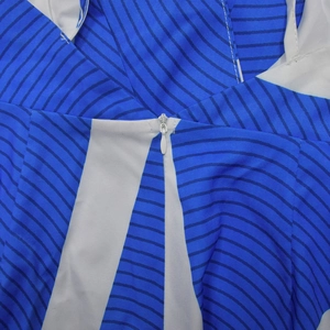 Close-up of the high-quality invisible zipper on a blue and white striped jumpsuit