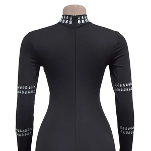 Detail view of the long back zipper on a black rhinestone embellished jumpsuit
