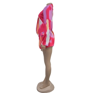 Side view of vibrant pink and orange abstract print blazer and shorts set for women