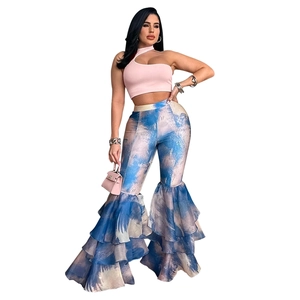 Détail du haut court rose à une épaule et du pantalon évasé à imprimé bleu et volants