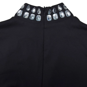 Detail of black high-neck jumpsuit featuring double-row rhinestone and back zipper