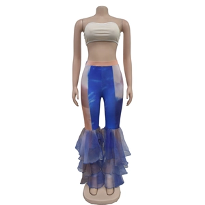 Détail du pantalon imprimé tie-dye avec ourlet à volants en mousseline et haut court blanc
