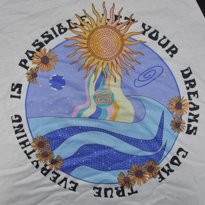 Detail of colorful retro sun and flower print on white fabric with motivational text