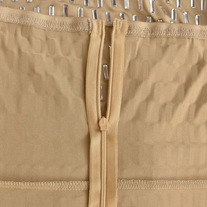 Macro detail of champagne dress featuring rectangular rhinestones and hidden zipper closure