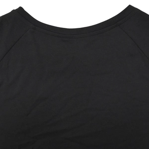 Close-up of raglan sleeve stitching and round neckline on a black short sleeve top