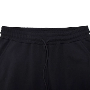 Detail of the elastic waistband with adjustable drawstring on black trousers