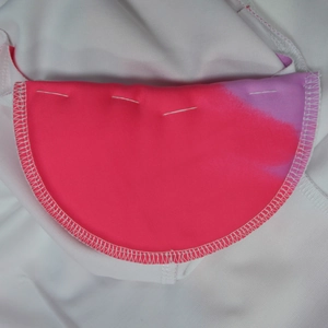 Close-up of pink and purple gradient fabric stitched on white mesh fabric with lockstitch